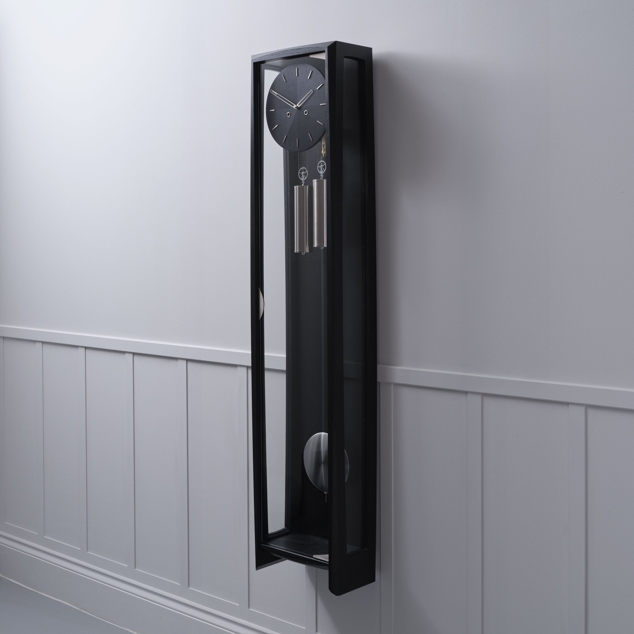 The Froxfield Wall Regulator showing a Black oak wall clock with pendulum.