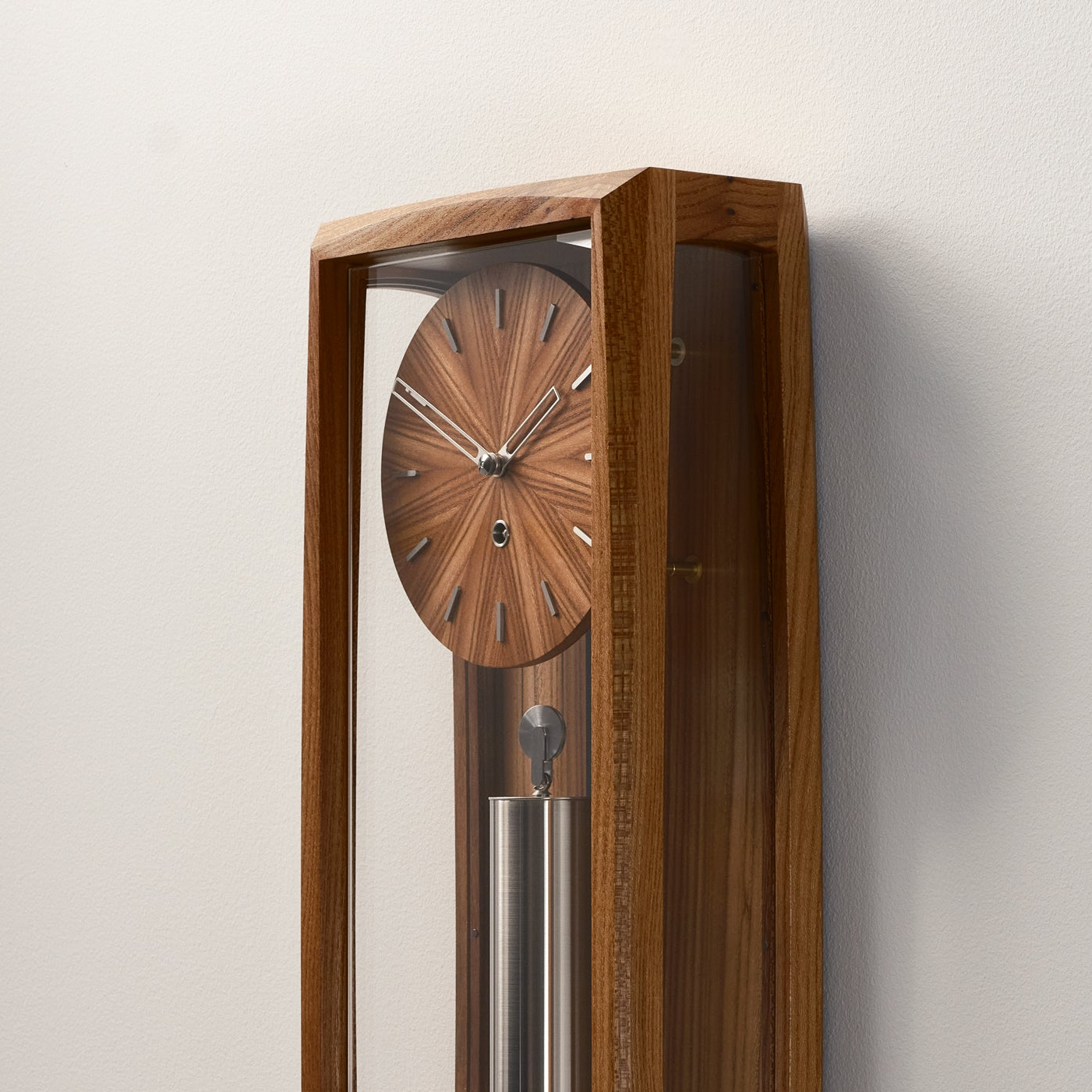 Close up of the dial and pendulum of a  Froxfield Wall Clock in Elm.